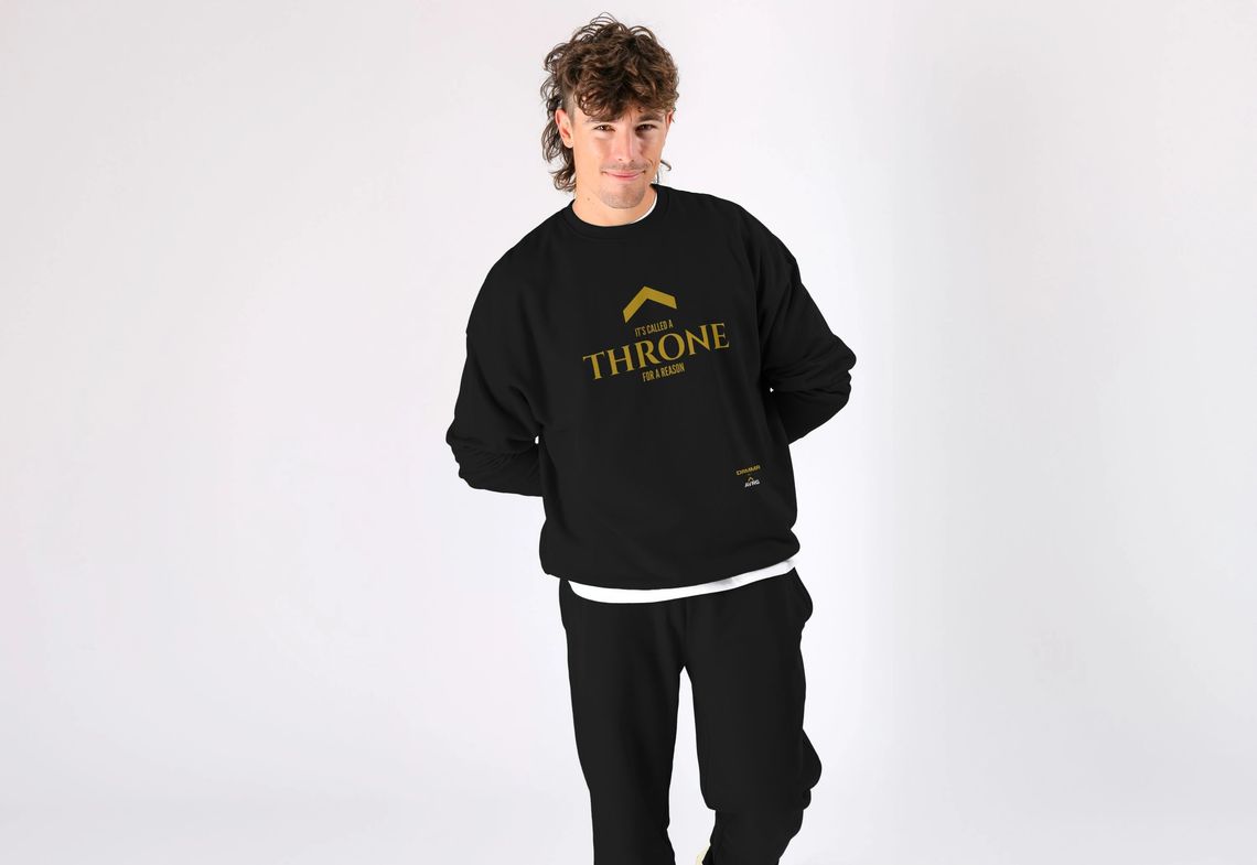 man wearing an oversized relaxed jumper from Above Average Clothing DRMMR identity. The slogan reads 'it's called a THRONE for a reason' man wearing an oversized relaxed jumper from Above Average Clothing DRMMR identity. The slogan reads 'it's called a THRONE for a reason'