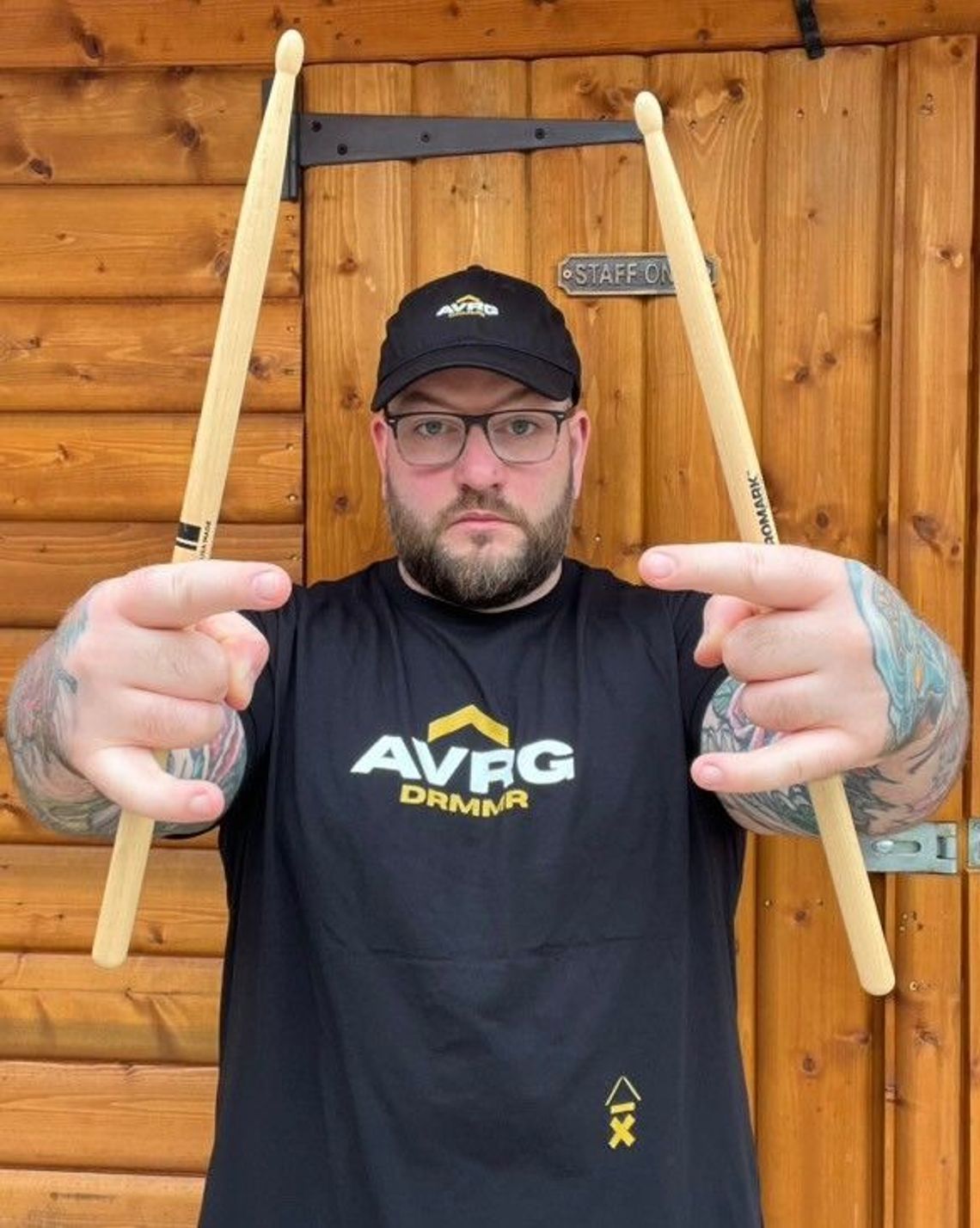 Lloyd Drums, aka @lloyddrums, wearing his black Above Average drummer identity t shirt and baseball cap