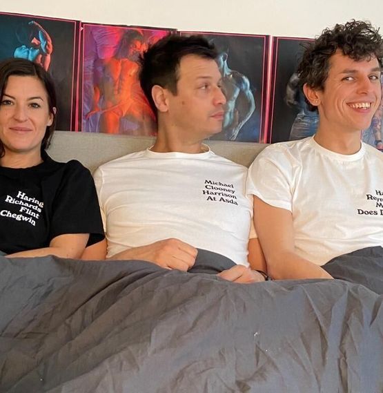 Three stunners in a bed wearing Branded + Moniker t-shirts. Buzz is wearing a black Keith t-shirt with white print saying Haring, Richards, Flint and Chegwin. Martyn's wearing a white George t-shirt with black print saying Michael, Clooney, Harrison, At Asda and Carl's wearing a light pink Debbie t-shirt with black print saying Harry, Reynolds, McGee and Does Dallas.